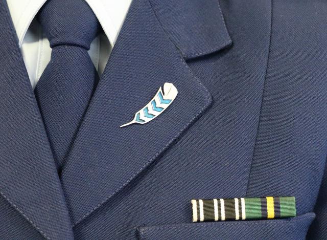 The Huia Pin worn on the lapel of a New Zealand Police uniform, alongside service ribbons.